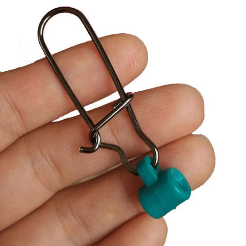 Close-up of 100 Pieces Fishing Line Sinker Slides With 8 Duo Lock Snaps, stainless steel, green, held in hand.