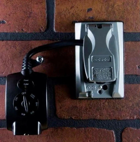 Top Shelf Outdoor Plug In Mechanical Timer Featuring Dusk To Dawn Activation and a grounded outlet mounted on a brick wall.