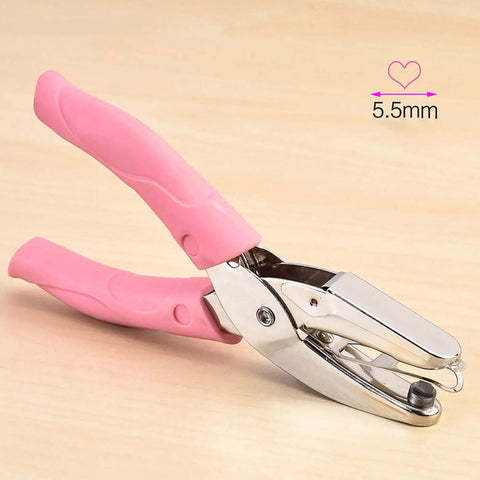 Heart Shaped Hole Punch For Crafting, 6.3 Inch Handheld Paper Punch With 1/4 Inch Heart Hole, pink leather cover, on wood surface