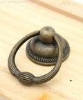 Close-up of a single vintage antique brass drop ring pull for drawers, 1.4-inch ring size, 2.1-inch height, retro style