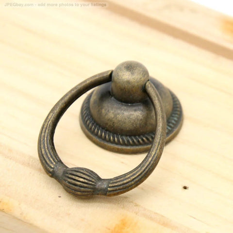 Close-up of a single vintage antique brass drop ring pull for drawers, 1.4-inch ring size, 2.1-inch height, retro style