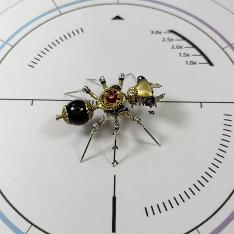 Mechanical Ant 3D Metal Model Kit with 130 Plus Pieces, Steampunk DIY Build for Adults and Teens, Creative Desk Display, Dope Gift for Engineers, Hobbyists, and Collectors. Brass and black metal ant model on a white scale mat.