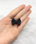 60Pc Glossy Black Disco Ball Beads With Sparkly Rhinestone Perfect for Diy Jewelry Crafting Dazzling Necklace Charms or Bracelet Spacers Add Dope Swag to Your Creations 21.5X30Mm Size for Ultimate Bling Effects and Vibe Ups. A black rhinestone bow held in hand.