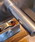 RHKING mini lathe burnishing tool, close-up view, silver metal, installed on a lathe with a cylindrical shaft and workpiece.