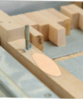 100 Piece Hardwood Biscuit Joiner Set for Woodworkers Tongue and Groove Board Carving Tenon Tool Kit on a workbench with a clamp.