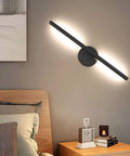Black Wall Sconce Rotatable 360 Degree LED Light Fixture for Bedroom with warm white glow above wooden bed and nightstand