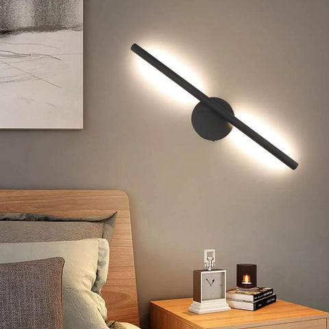 Black Wall Sconce Rotatable 360 Degree LED Light Fixture for Bedroom with warm white glow above wooden bed and nightstand