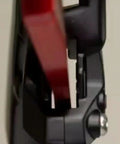 Close-up of a red aluminum Piston Press Tool for SRAM Brake Caliper in use, showing caliper and tool alignment
