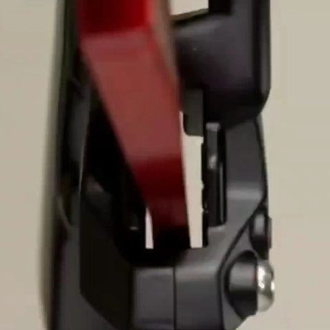 Close-up of a red aluminum Piston Press Tool for SRAM Brake Caliper in use, showing caliper and tool alignment