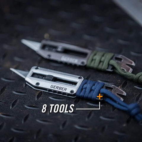 Close-up of two Prybrid X EDC Multitool Pocket Knives with retractable box cutter blades and paracord wraps on metal surface.