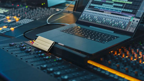 T7 Shield 1TB Portable External SSD Up To 1050 MB Per Second USB 3.2 Gen2 next to laptop in music production studio