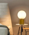 11 Inch Modern Gold Globe Table Lamp With Milk White Glass Shade and Sturdy Metal Base on bedside table in bedroom