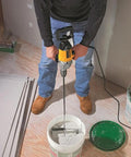 Man using Badass Torque One Half Inch Spade Handle Corded Drill With Nine Point Zero Amp Motor And Reversing Switch over paint bucket.