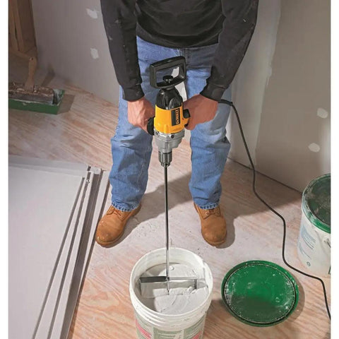 Man using Badass Torque One Half Inch Spade Handle Corded Drill With Nine Point Zero Amp Motor And Reversing Switch over paint bucket.