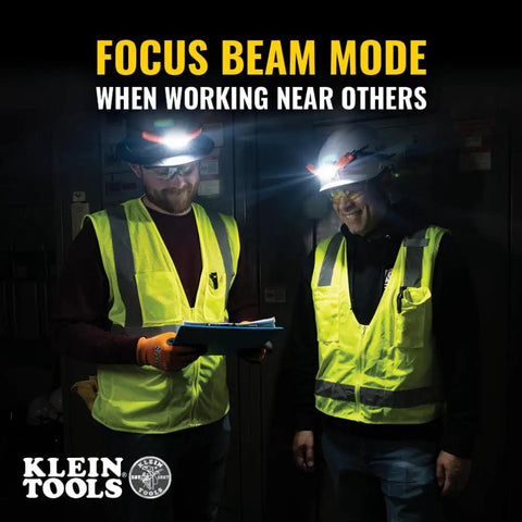 Focus beam mode in use with rechargeable LED wide beam headlamp with hard hat mounts for work, 770 lumens, lighting two workers.