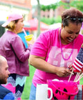 Smiling woman holding Handheld 5x8 Inch American Flags On Wooden Sticks 12 Pack Small US Flags With Safe Spear Tops at outdoor event