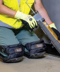 Person using caulk gun wearing All Day Comfort Hinged Gel Knee Pads With Slip Resistant Rubber Caps, Quick Release Clips And Adjustable Straps