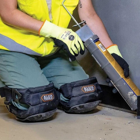 Person using caulk gun wearing All Day Comfort Hinged Gel Knee Pads With Slip Resistant Rubber Caps, Quick Release Clips And Adjustable Straps