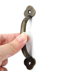 Hand holding 12 Pack Barn Door Handles Rustic Gate Pulls Bronze Metal Hardware Includes 24 Screws For Cabinet Garage Closet Drawer