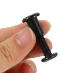 Top Shelf M6x25 Black Stainless Steel Binding Screw held in hand, ideal for secure furniture assembly and woodworking projects.