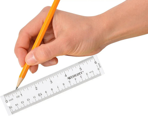 Hand holding Crystal Clear Acrylic Ruler 6 Inch Beveled Edge With Easy To Read Markings See Through Straight Edge for drawing.