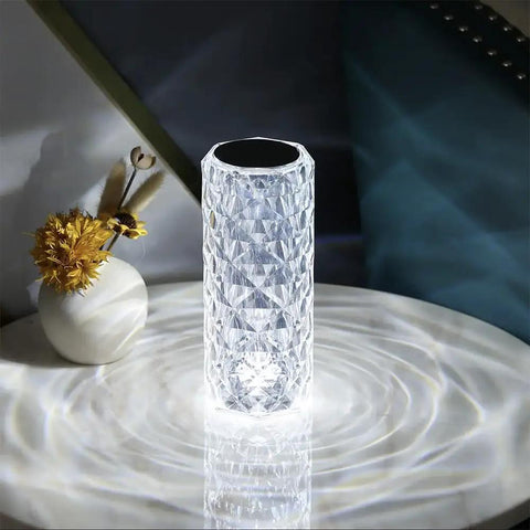 Lit Crystal Diamond Portable Table Lamp With 3 Color Touch Control on a white surface, reflecting light patterns.