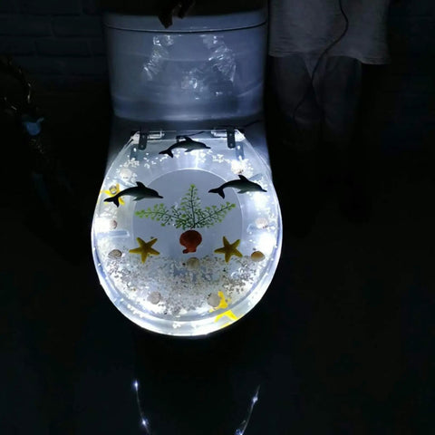 Slick Transparent Dolphin Toilet Seat Featuring Smooth Glide Soft Close Lid Cover And Built In Led Night Light illuminated design.