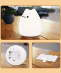 LED Cat Night Light For Kids Battery Powered Silicone Cat Nursery Night Light With 2 Soft Glow Modes on wooden table