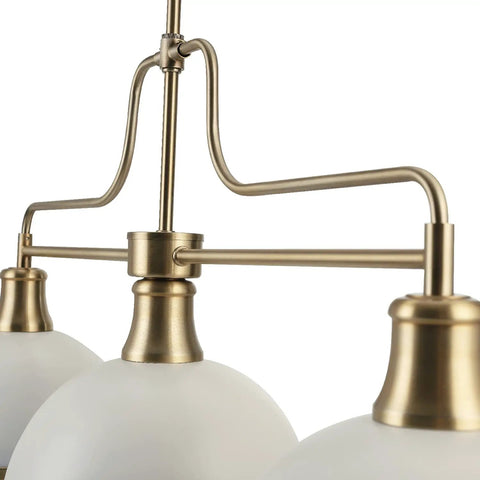 Close-up of Three Light Linear Chandelier In Matte White With Brass Accents, adjustable hanging, sloped or vaulted ceiling compatible.