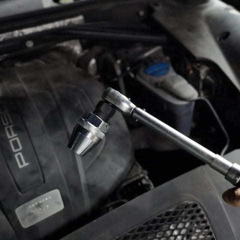 Damaged Bolt And Stud Extractor Tool For One Quarter Inch To One Half Inch Studs in use with manual wrench under car hood