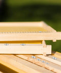 Stacked wooden frames with dowel and tenon transfer plugs set for woodworking 20 pcs doweling centering pins visible on edges.