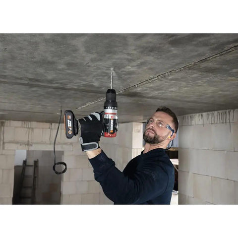 Man using a Brushless Cordless Hammer Drill With Two 20 Volt Batteries And Active Hammer Action for concrete overhead.