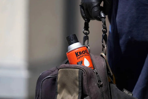 Person holding a bag with Aerokroil Penetrant Rust Penetrating Lubricant And Corrosion Inhibitor Oil For Chains Hinges And Stuck Metal Parts visible.