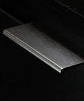 Close-up of brushed stainless steel finger edge pull handle installed on dark cabinet. Part of Finger Edge Pull Handle Set, 10 Pack.