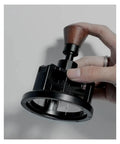 Heavy Duty 58 Millimeter Espresso Portafilter Needle Distributor With Built In Magnet held in hand for even coffee distribution.