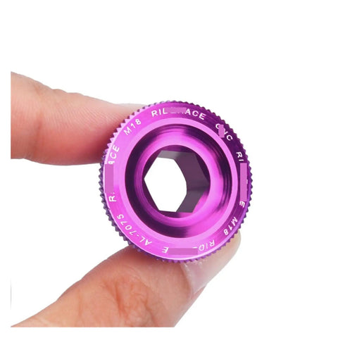 Purple CNC machined Aluminum Alloy Crank Arm Fixing Bolt And Crankset Nut For MTB Bikes, M18 size held between fingers.