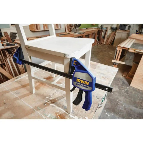 Heavy Duty One Handed Bar Clamp With Quick Change Spreader Removable Swivel Jaws And Non Marring Pads securing wooden chair