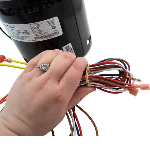 Close-up of hand holding wires of HVAC Blower Motor Three Quarter HP One Phase Three Speed 208 And 230 Volt 1075 RPM
