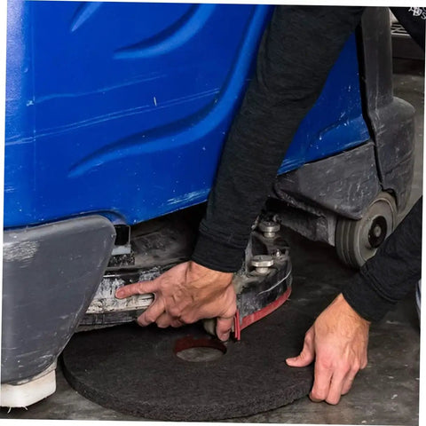 Person installs Five Pack 17 Inch Black Microfiber Floor Cleaning Pad For Polishing Scrubbing And Wax Removal on a floor machine.