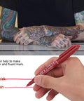 Smooth Double Ended Markers For Piercing And Art Projects, 10 Piece Set shown on tattooed hands using red ink pen.
