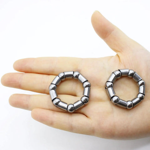 Hand holding 4 Piece Bike Ball Bearing Retainer Set With 8mm Balls, 38mm Outer Diameter, 24mm Inner Diameter, 5 By 16 Inch Ball Size.