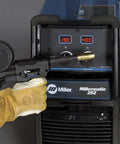 Smooth Rolling MIG Flux Core Welding Rig Tackles Mild Steel And Aluminum Like A Champ Dual Voltage 208 230VAC close-up of Miller welder settings with glove