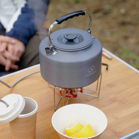 Two Point Two Liter Camping Kettle For Open Flame And Stove, fast boil, lightweight, anti-scald handle, on a table outdoors