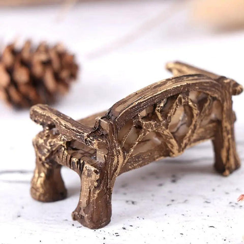 Brown resin miniature garden bench for fairy village dollhouse decor, featuring intricate detailing on legs and backrest.