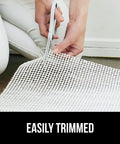 Person trimming Extra Strong Rug Pad Gripper That Keeps Rugs From Moving On Tile Or Hardwood Floors, Slip Resistant Underlay Cushions, 2x3 feet.