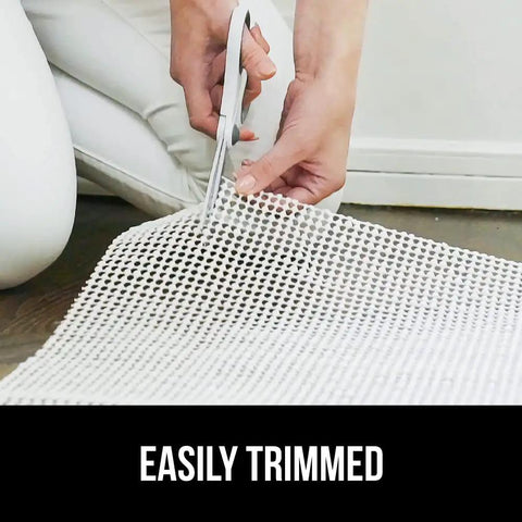 Person trimming Extra Strong Rug Pad Gripper That Keeps Rugs From Moving On Tile Or Hardwood Floors, Slip Resistant Underlay Cushions, 2x3 feet.