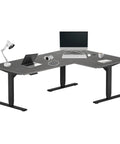 Heavy Duty Electric Standing Desk L Shaped 72 By 48 Inch Corner Workstation Table with laptop and accessories on surface.