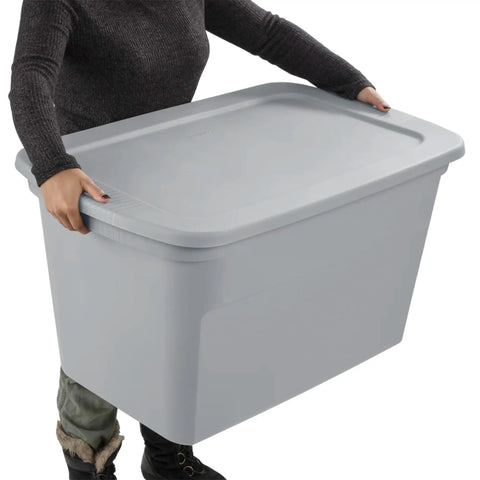 Person carrying a Six Pack Heavy Duty 30 Gallon Plastic Storage Container With Secure Lid, gray in color, ideal for home organization.