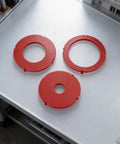 Rock Solid Router Table Insert Rings 3 Piece Set For Bosch RA1171 RA1180 RA1181 Models red precision drop-in rings on a flat surface.