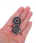 Sick 8 Piece 608RS Black Roller Skate Bearings With Pro Grade Carbon Steel Design For Loud Spins And Low Friction Glide Runs Smooth On Indoor Quads Or Longboards At Night No Grind Resistance Or Squeaky Wheels Ruining Your Ride Quality. 608RS black sealed bearing in hand